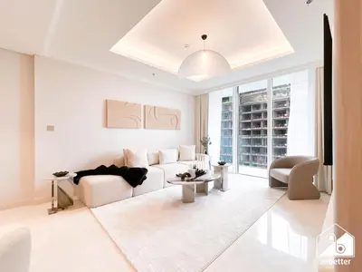 a white living room with a couch and a table at Elegant 1B by the Beach & iconic Views in Dubai