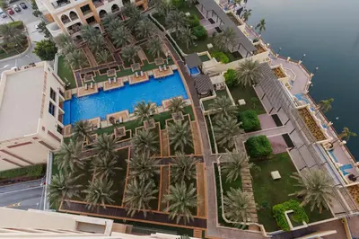 an aerial view of a resort with a pool and palm trees at Panoramic Palm Jumeirah view 1 BedRoom Apartment- Holistay Luxury Collection in Dubai