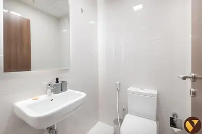 a white bathroom with a sink and a toilet at Vogue JVC Jeewar Tower near Circle Mall, One Bedroom Apartment with Balcony and City View, Access to all Amenities in Dubai