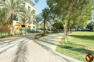 a street with palm trees and a house and a sidewalk at Vogue JVC Jeewar Tower near Circle Mall, One Bedroom Apartment with Balcony and City View, Access to all Amenities in Dubai
