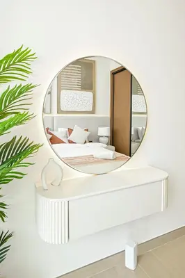 a round mirror on a wall with a bed and a bed at Golden Stays - Binghatti Tulip I Chic 1BR Apartment I Balcony Views I JVC Dubai in Dubai