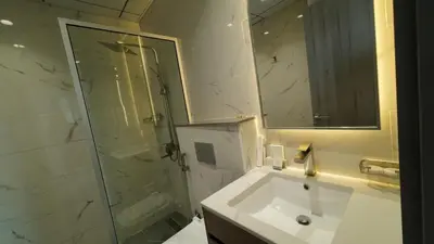 a bathroom with a shower and a sink and a mirror at High Floor 2 Bedroom in V Tower in Dubai