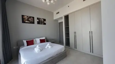 a bedroom with a large white bed with red pillows at High Floor 2 Bedroom in V Tower in Dubai