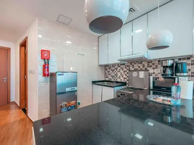 a kitchen with white cabinets and a counter top at Cozy Studio Themed Designed In JVT in Dubai