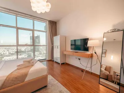 a bedroom with a bed and a flat screen tv at Cozy Studio Themed Designed In JVT in Dubai