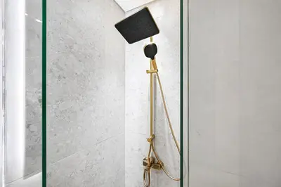 a tripod floor lamp with a speaker on top of it at Golden Stays - Private Pool in Binghatti Tulip I Prime JVC 2BR I Balcony Access in Dubai