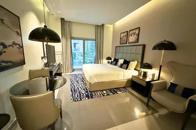 a bedroom with a bed and a desk and a chair at Stunning Burj Views Studio Mins to Dubai Mall 603 in Dubai