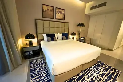 a bedroom with a large bed and a blue rug at Stunning Burj Views Studio Mins to Dubai Mall 603 in Dubai