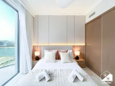 a bedroom with a bed and a large window at Seaside 1BR Retreat , Beach & Atlantis Views in Dubai