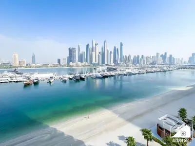 a marina with boats in the water and a city at Seaside 1BR Retreat , Beach & Atlantis Views in Dubai