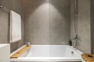a white bath tub in a bathroom with a shower at District One Dubai Lagoon View Near Downtown in Dubai