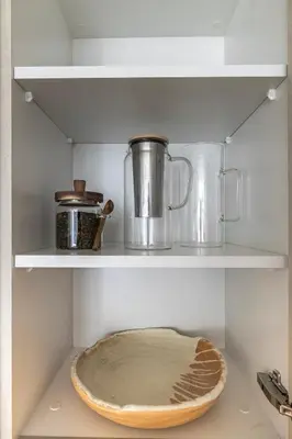 a shelf with two pots and pans on it at District One Dubai Lagoon View Near Downtown in Dubai