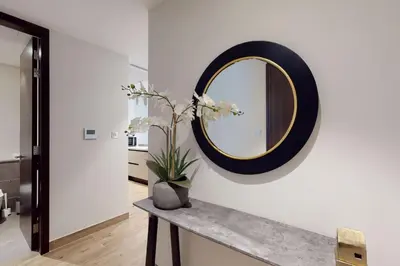 a mirror on a wall with a vase on a counter at Citihome - Luxury 1BR Dubai Marina in Dubai