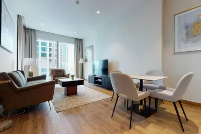 a living room with a table and chairs and a television at Citihome - Luxury 1BR Dubai Marina in Dubai