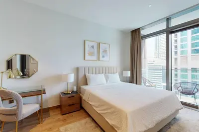 a bedroom with a bed and a desk and a window at Citihome - Luxury 1BR Dubai Marina in Dubai