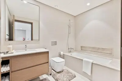 a bathroom with a tub and a toilet and a sink at Citihome Luxury Finishing 1BR City View in Dubai
