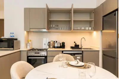 a kitchen with a white table and chairs in a kitchen at CitiHome Modern and Cozy Prime Location in Dubai