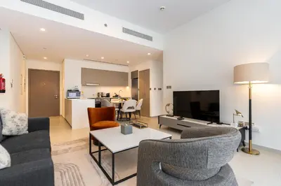 a living room with a couch and chairs and a tv at CitiHome Modern and Cozy Prime Location in Dubai