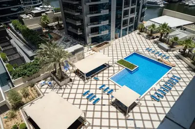 an overhead view of a pool with chairs and umbrellas at Upgraded Bay Central 1 Bed - Marina and Pool View in Dubai