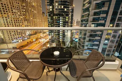 a table and chairs on a balcony with a view of a city at Upgraded Bay Central 1 Bed - Marina and Pool View in Dubai