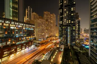 a city skyline at night with traffic and tall buildings at Upgraded Bay Central 1 Bed - Marina and Pool View in Dubai