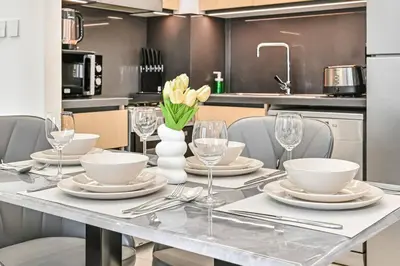 a dining room table with plates and wine glasses at 1BR Stay in Burj Crown, Dubai in Dubai