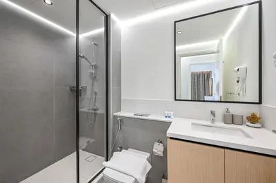 a bathroom with a shower and a sink and a mirror at 1BR Stay in Burj Crown, Dubai in Dubai