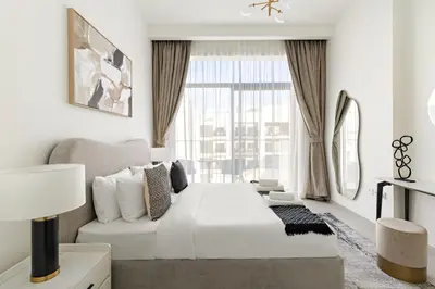 a white living room with a large window at VayK - Stylish 2BR with Premium Amenities in JVC in Dubai