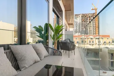 a living room with a couch and a large window at VayK - Stylish 2BR with Premium Amenities in JVC in Dubai