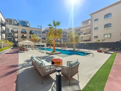 a patio with two chairs and a pool in a building at VayK - Contemporary and Cozy Studio in JVC in Dubai