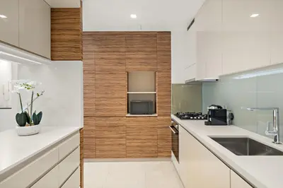 a kitchen with white counters and wooden walls at VayK - Luxurious 1BR in JLT with Premium Amenities in Dubai