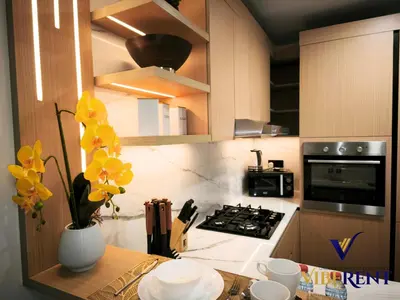 a kitchen with a counter with yellow flowers in a vase at Luxury 1BHK Pool Paddle Sauna in Dubai
