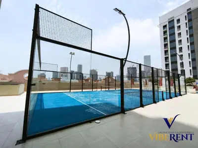 a tennis court on the roof of a building at Luxury 1BHK Pool Paddle Sauna in Dubai