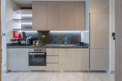 a kitchen with white cabinets and a counter top at Iconic Burj Khalifa View- Aspin Studio in Dubai