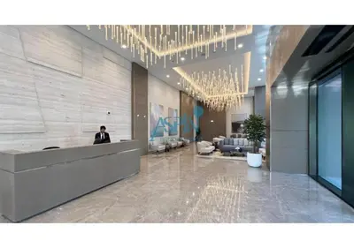 a man standing in a lobby with a reception desk at Iconic Burj Khalifa View- Aspin Studio in Dubai
