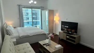 a bedroom with a bed and a tv and a couch at Zing Holiday Home in Dubai