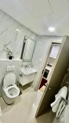 a bathroom with a toilet and a sink and a mirror at Zing Holiday Home in Dubai