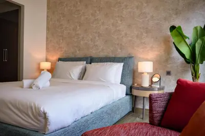 a bedroom with a large bed with two lamps and a chair at Sobha Hartland Greens 2BR near Dubai Mall in Dubai