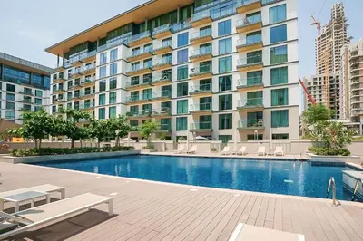 a swimming pool in front of a large building at Sobha Hartland Greens 2BR near Dubai Mall in Dubai