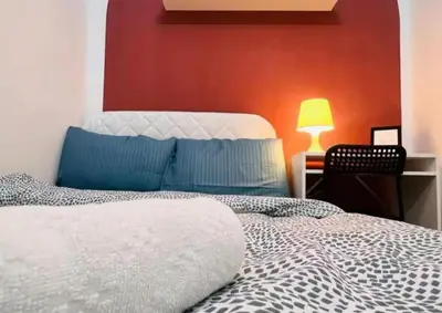 a bedroom with a white bed and a red wall at City Edge Room In Barsha Heights Tecom in Dubai