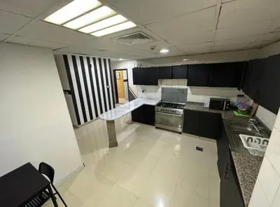 a kitchen with black and white cabinets and a stove at Solo Comfort Corner In Barsha 1 in Dubai