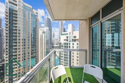 a balcony with two chairs and a view of the city at Iconic Burj & Fountain View Retreat! in Dubai