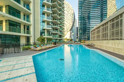 a swimming pool in a city with tall buildings at Gala Guests - Urban Oasis Apartments Near Burj Khalifa & Downtown Dubai in Dubai