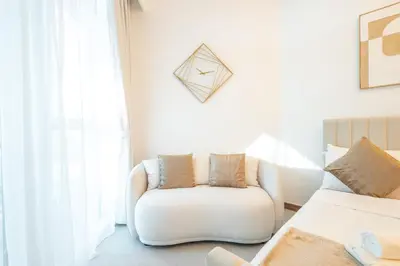 a living room with a white couch and a window at Gala Guests - Urban Oasis Apartments Near Burj Khalifa & Downtown Dubai in Dubai