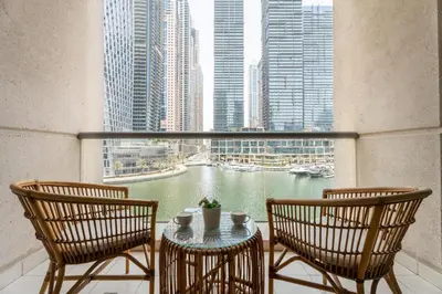 a balcony with a table and chairs and a view of a river at Gala Guests - Iris Blue Luxe Living Collection in Dubai