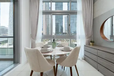 a dining room with a table and chairs and windows at Gala Guests - Iris Blue Luxe Living Collection in Dubai