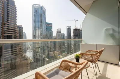 a balcony with two chairs and a view of the city at Tranquil Studio at Botanica in Dubai
