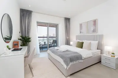 a bedroom with a bed and a desk and a mirror at Gala Guests - Princess Tower Suites Dubai Marina in Dubai