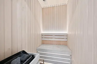 a sauna with a bench and a sink at Dusk by Binghatti by Rentujemy in Dubai