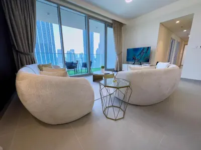 a living room with two chairs and a large window at Downtown Gem Apt, Burj View Bliss in Dubai